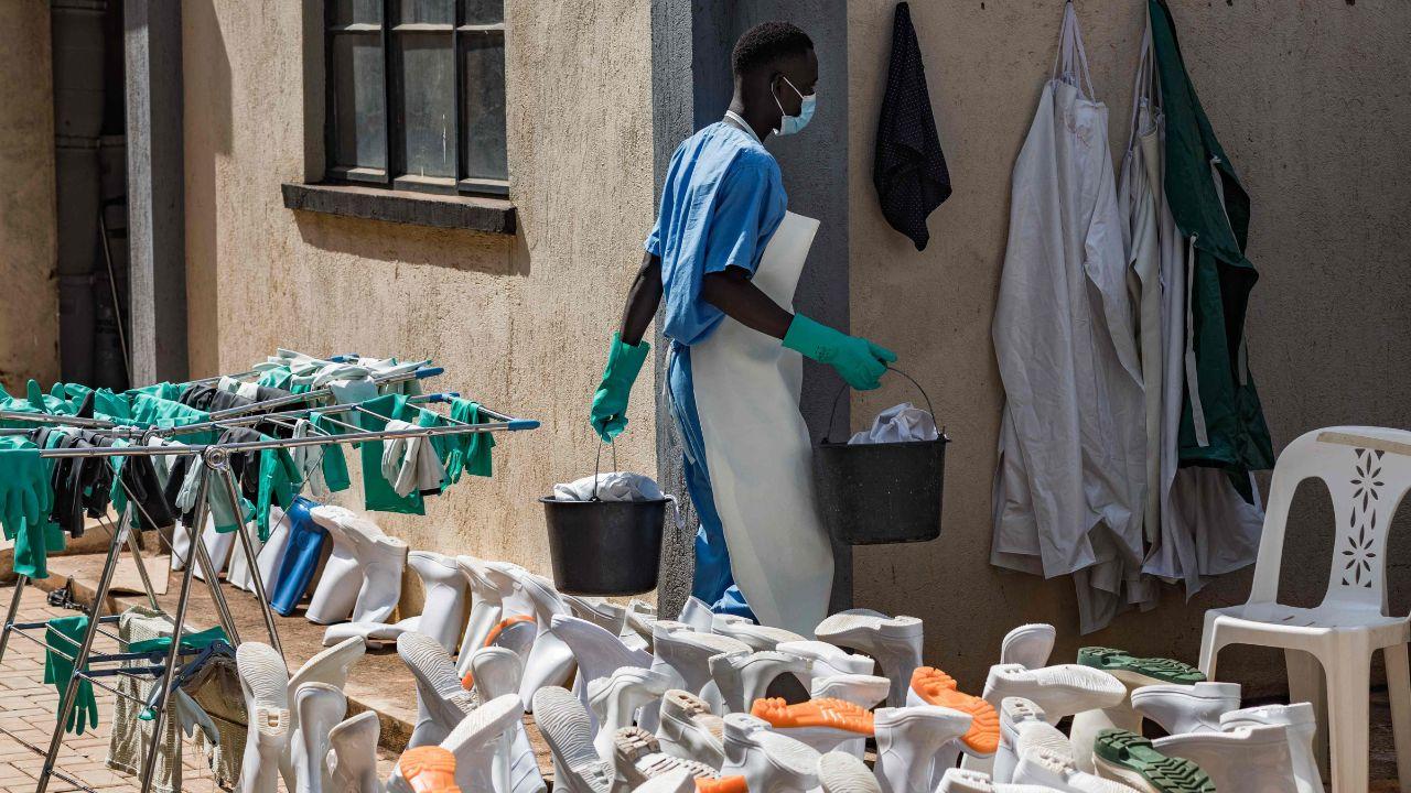A health worker carries buckets at an isolation unit in Kampala, Uganda. PIC/AFP